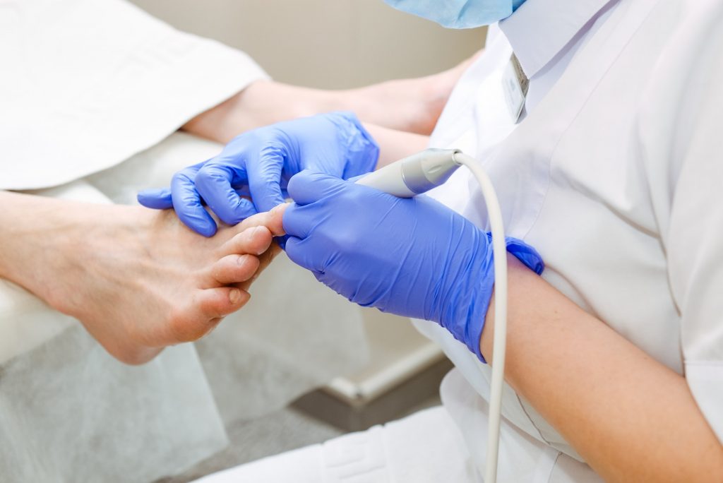 Close up professional machinery process of a male pedicure at a beauty salon